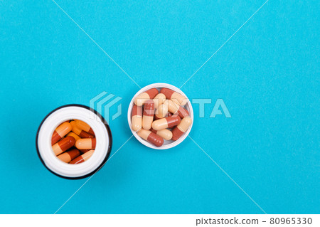 Pharmaceutical Industry and Medicinal Products - Colored Pills on Blue Table Pharmaceutical Industry and Medicinal Products - Colored Pills on Blue Table 80965330