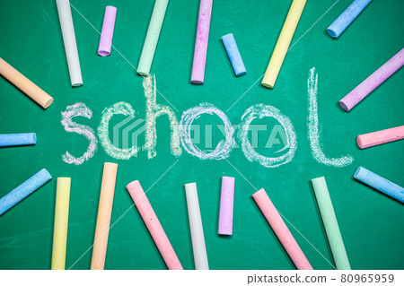 Multicolored chalks on a green chalkboard 80965959