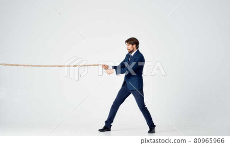 business man in a suit with a rope in his hands manager office light background business man in a suit with a rope in his hands manager office light background 80965966