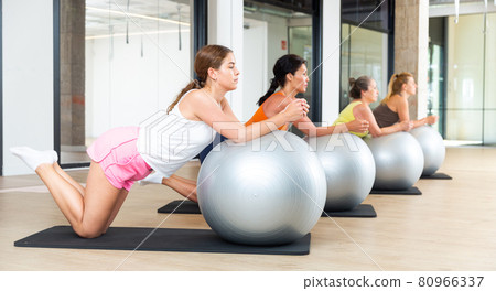 Women lying on gymnastic ball. Fitness workuot in gym Women lying on gymnastic ball. Fitness workuot in gym 80966337
