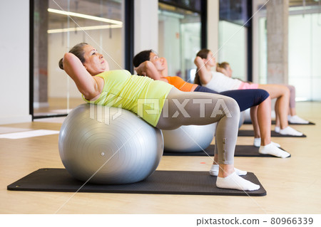 Women lying on gymnastic ball. Fitness workuot in gym Women lying on gymnastic ball. Fitness workuot in gym 80966339