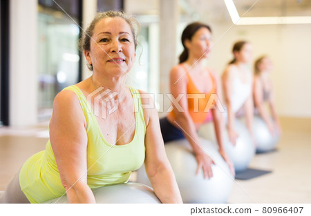 Women of different ages doing upward-facing dog pose 80966407