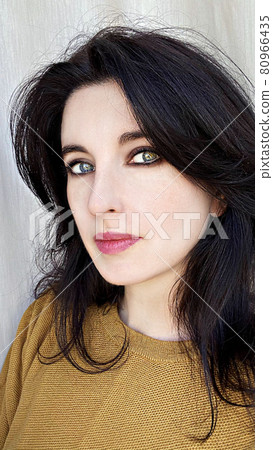 A young woman in a golden colored jumper 80966435