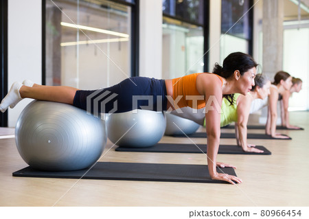 Women lying on gymnastic ball. Fitness workuot in gym Women lying on gymnastic ball. Fitness workuot in gym 80966454