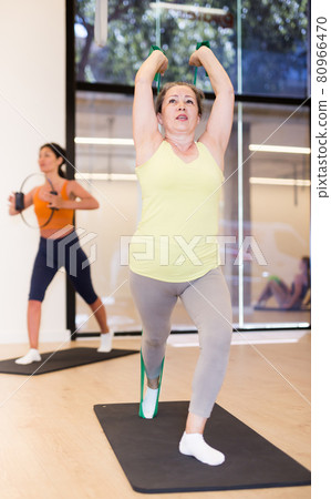 Elderly woman doing pilates exercise with expander tape Elderly woman doing pilates exercise with expander tape 80966470