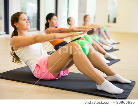 Sporty women doing exercises with pilates balls during group training Sporty women doing exercises with pilates balls during group training 80966650