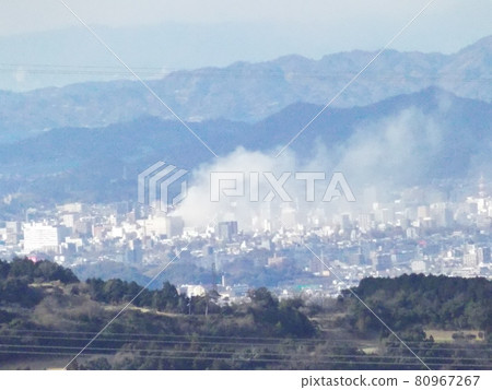 Fire in the city seen from a distant mountainous area Fire in the city seen from a distant mountainous area 80967267