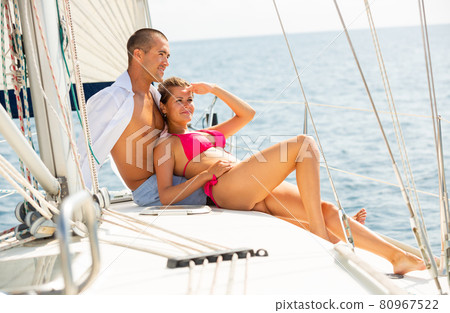 Couple enjoying sea trip on sailboat 80967522