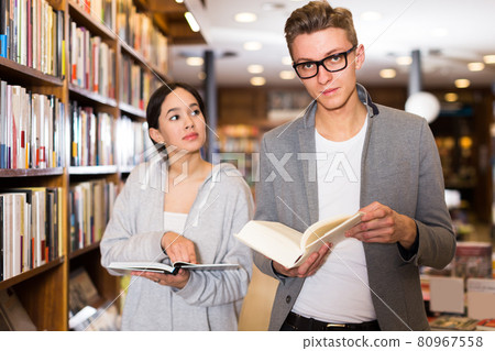 couple choosing and discussing literature 80967558