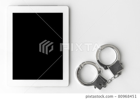 平板電腦終端和手銬。網絡犯罪圖片 平板電腦終端和手銬。網絡犯罪圖片 80968451