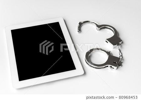 平板電腦終端和手銬。網絡犯罪圖片 80968453