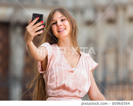 female standing in the street and taking selfie female standing in the street and taking selfie 80968564