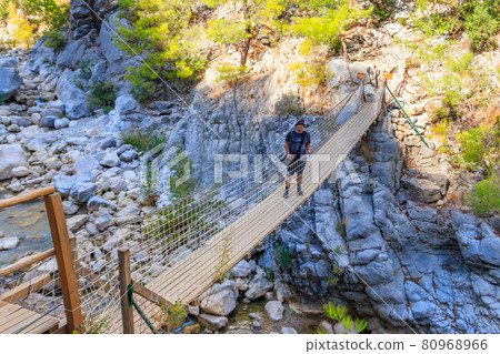 Young man standing on suspension wooden bridge in Goynuk canyon in Antalya province,Turkey 80968966