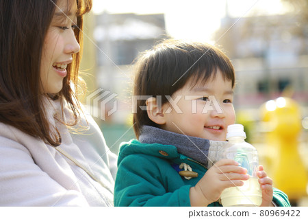 Boy and mother drinking juice 80969422