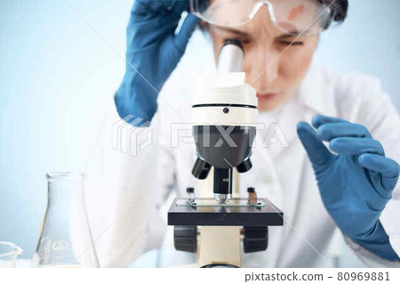woman in laboratory looking through microscope close-up biotechnology science 80969881