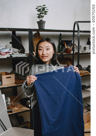 Professional young female tailor working in workshop Professional young female tailor working in workshop 80970268