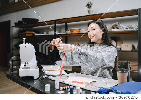 Woman with measuring tape work in workshop Woman with measuring tape work in workshop 80970270
