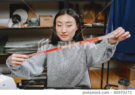 Woman with measuring tape work in workshop 80970273