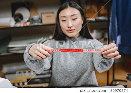 Woman with measuring tape work in workshop 80970274
