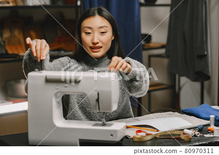 Professional young female tailor working in workshop 80970311