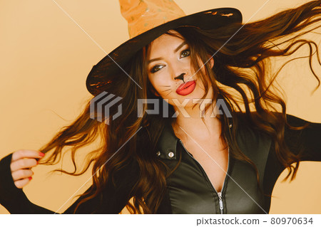 Young woman in haloween costume pose on color background Young woman in haloween costume pose on color background 80970634