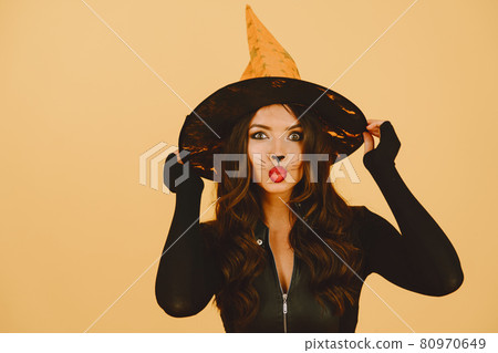 Young woman in haloween costume pose on color background Young woman in haloween costume pose on color background 80970649