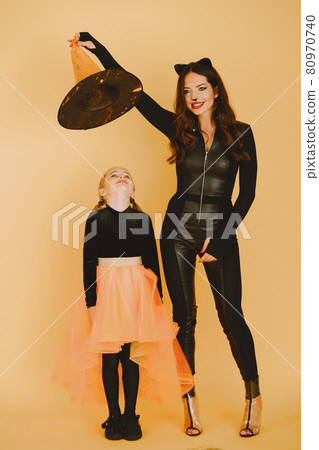 Mother and daughter in haloween costumes pose isolated 80970740