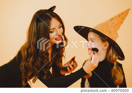 Mother applying Halloween make up to daughter 80970800