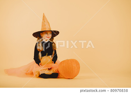 Beautiful girl witch on a orange background Beautiful girl witch on a orange background 80970838
