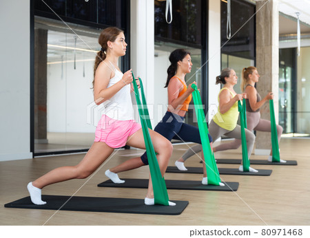 Women are doing stretching exercise with green resistance bands. Teamwork, good mood and healthy lifestyle concept 80971468