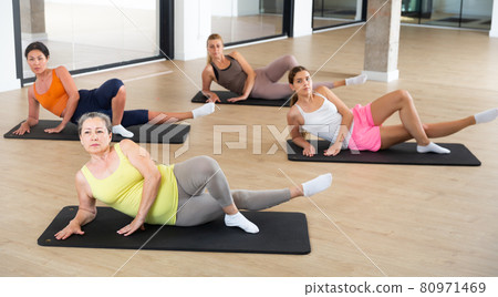 Women exercising during yoga class in modern fitness center Women exercising during yoga class in modern fitness center 80971469