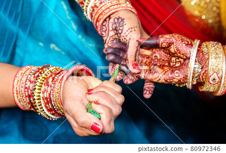 Artist applying henna tattoo on women hands. 80972346