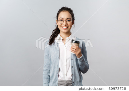 Lifestyle, people and emotions concept. Attractive young woman, female employee buying take-away coffee on her way to work office, smiling cheerful, casual ordinary day with coworkers doing their job 80972726