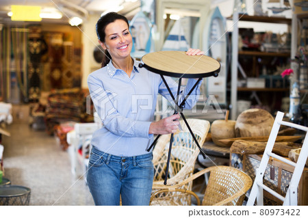 Woman customer choosing wooden stool Woman customer choosing wooden stool 80973422