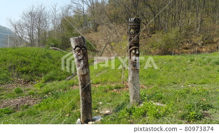 A traditional jangseung (totem pole) in the shape of a human head erected at the entrance to a temple in a Korean village A traditional jangseung (totem pole) in the shape of a human head erected at the entrance to a temple in a Korean village 80973874