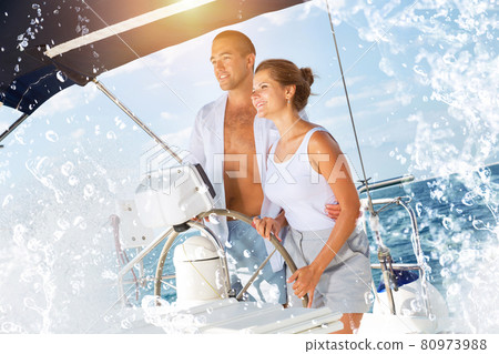 Man and woman steering pleasure yacht 80973988