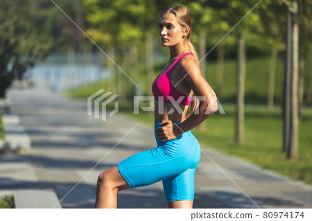 Young slim sportive caucasian woman working out, doing fitness, yoga in the park or on city street. Young slim sportive caucasian woman working out, doing fitness, yoga in the park or on city street. 80974174