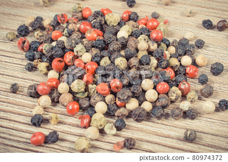 Colored pepper on wooden board as cooking spice 80974372