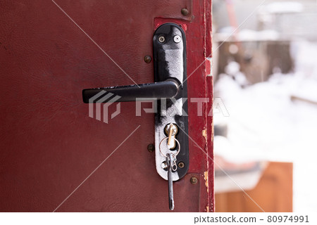 Frozen door lock on old brown doors. 80974991