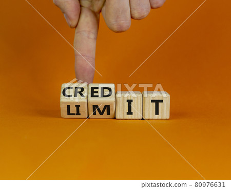 Credit limit symbol. Businessman turns wooden cubes and changes the word 'limit' to 'credit'. Beautiful orange table, orange background, copy space. Business and credit limit concept. 80976631