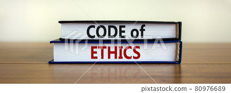 Code of ethics symbol. Concept words 'Code of ethics' on books on a beautiful wooden table, white background. Business and code of ethics concept. Copy space. 80976689