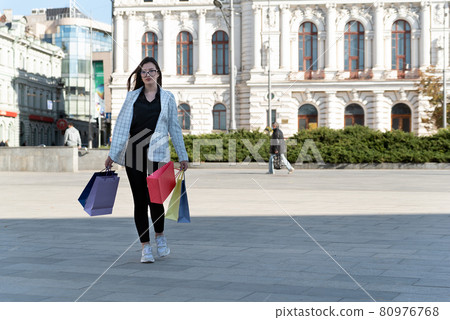 Full size photo of women tourist with paper shopping bags on beautiful building background 80976768