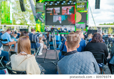 Participants of open air conference listening to speaker Participants of open air conference listening to speaker 80976974