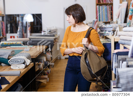 Thoughtful woman in fabric shop 80977304