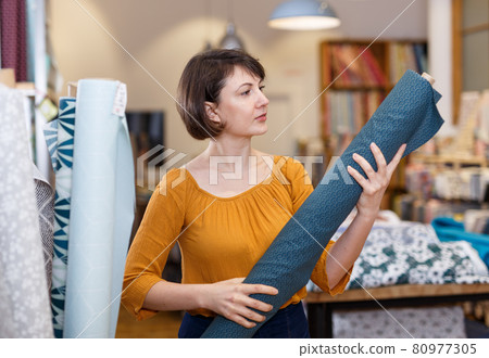 Woman choosing textiles in shop 80977305