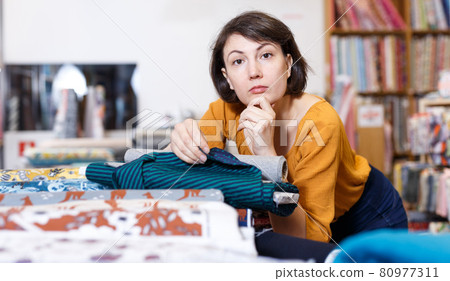 Woman looking for cloth in shop Woman looking for cloth in shop 80977311