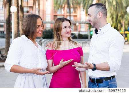 Young male is acquaintance with girls who are walking Young male is acquaintance with girls who are walking 80977615