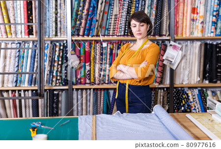 Saleswoman next to cutting table Saleswoman next to cutting table 80977616