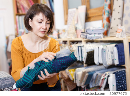 Brunette choosing fabric in store 80977673