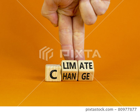 Climate change symbol. Businessman turns cubes with words 'Climate change'. Beautiful orange background. Climate change and ecological concept. Copy space. 80977877